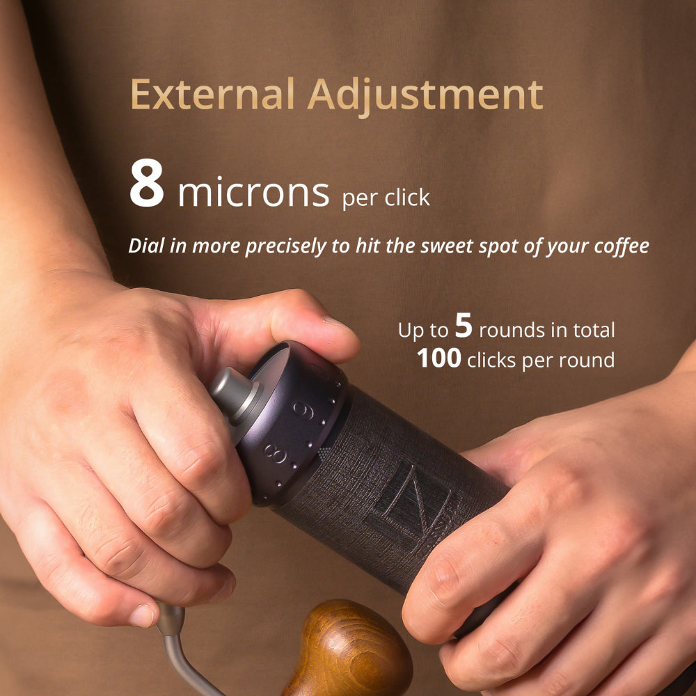 1Zpresso J-Ultra: Black manual coffee grinder with wooden handle being used. Shows adjustment details.