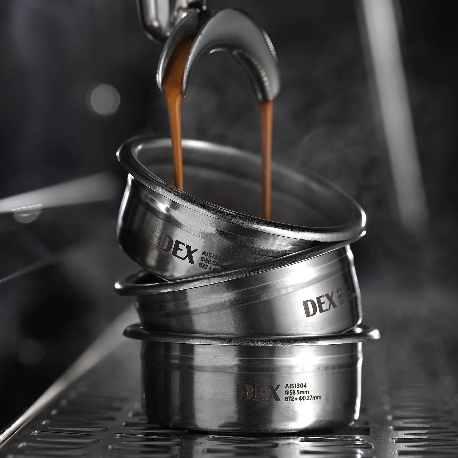 Stacked MHW-3BOMBER DEX 58mm stainless steel filter baskets with espresso pouring. Precision coffee tool.