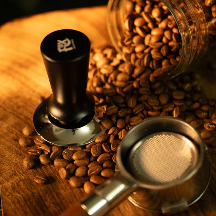 Fix Coffee tamper, portafilter & beans. Black handle, silver base. Automatic spring reset for consistent tamping.