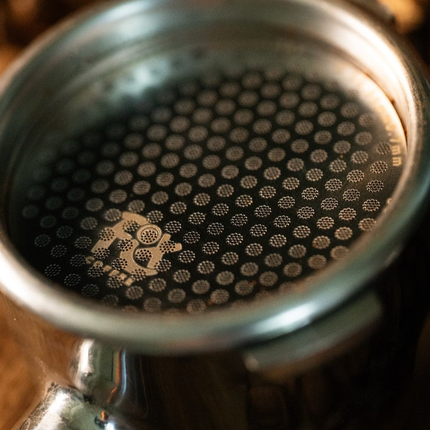 FIX COFFEE titanium-plated espresso puck screen, 58mm. Stainless steel with a circular dot pattern. Brand logo at center.