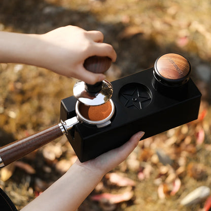 MHW-3BOMBER black ABS portafilter holder being used with tamper and portafilter. 