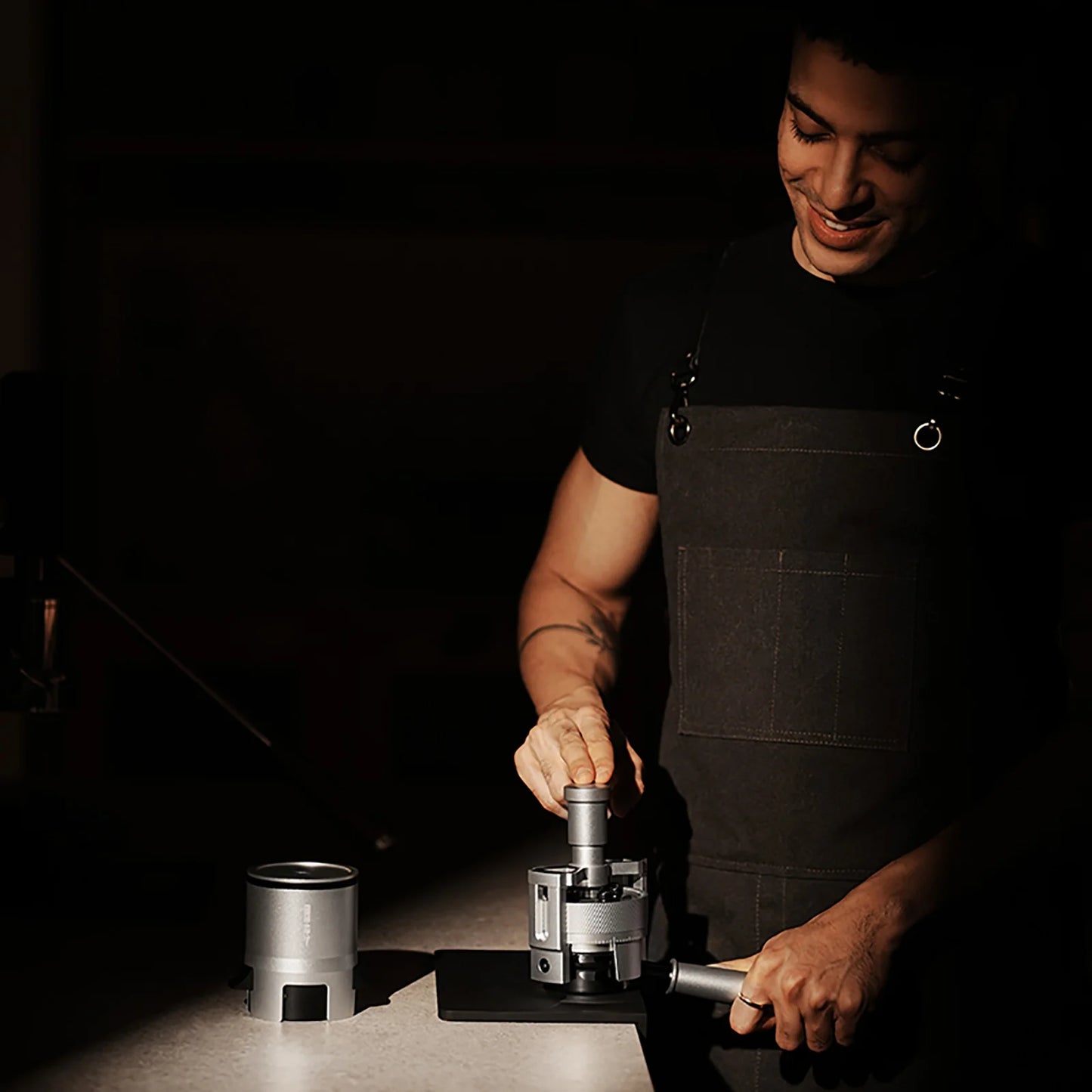 MHW-3BOMBER SE Pro espresso shaker funnel in use, silver metal. Dosing coffee grounds evenly.