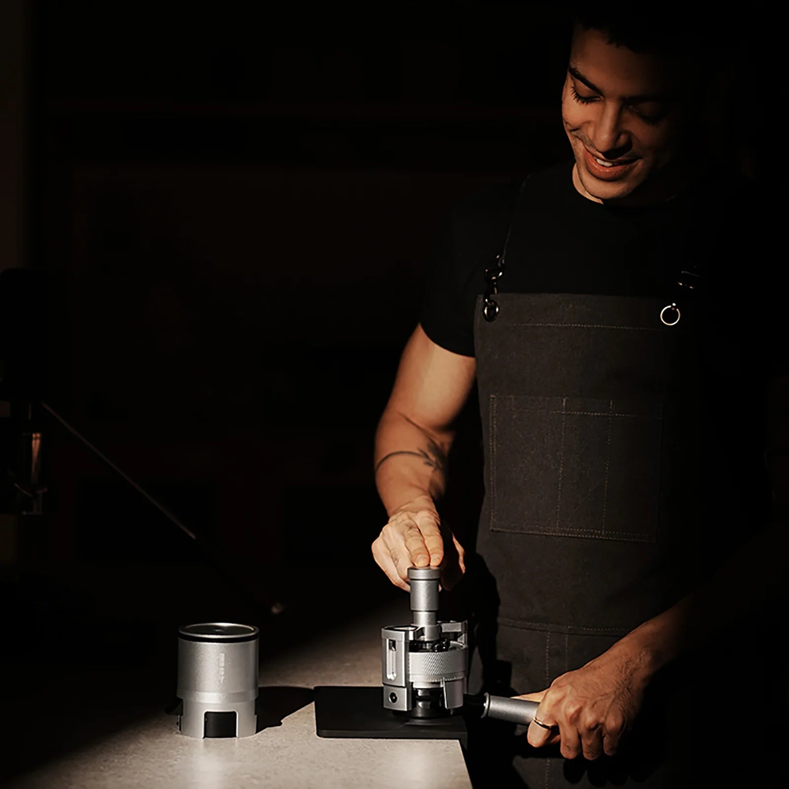 MHW-3BOMBER SE Pro espresso shaker funnel in use, silver metal. Dosing coffee grounds evenly.