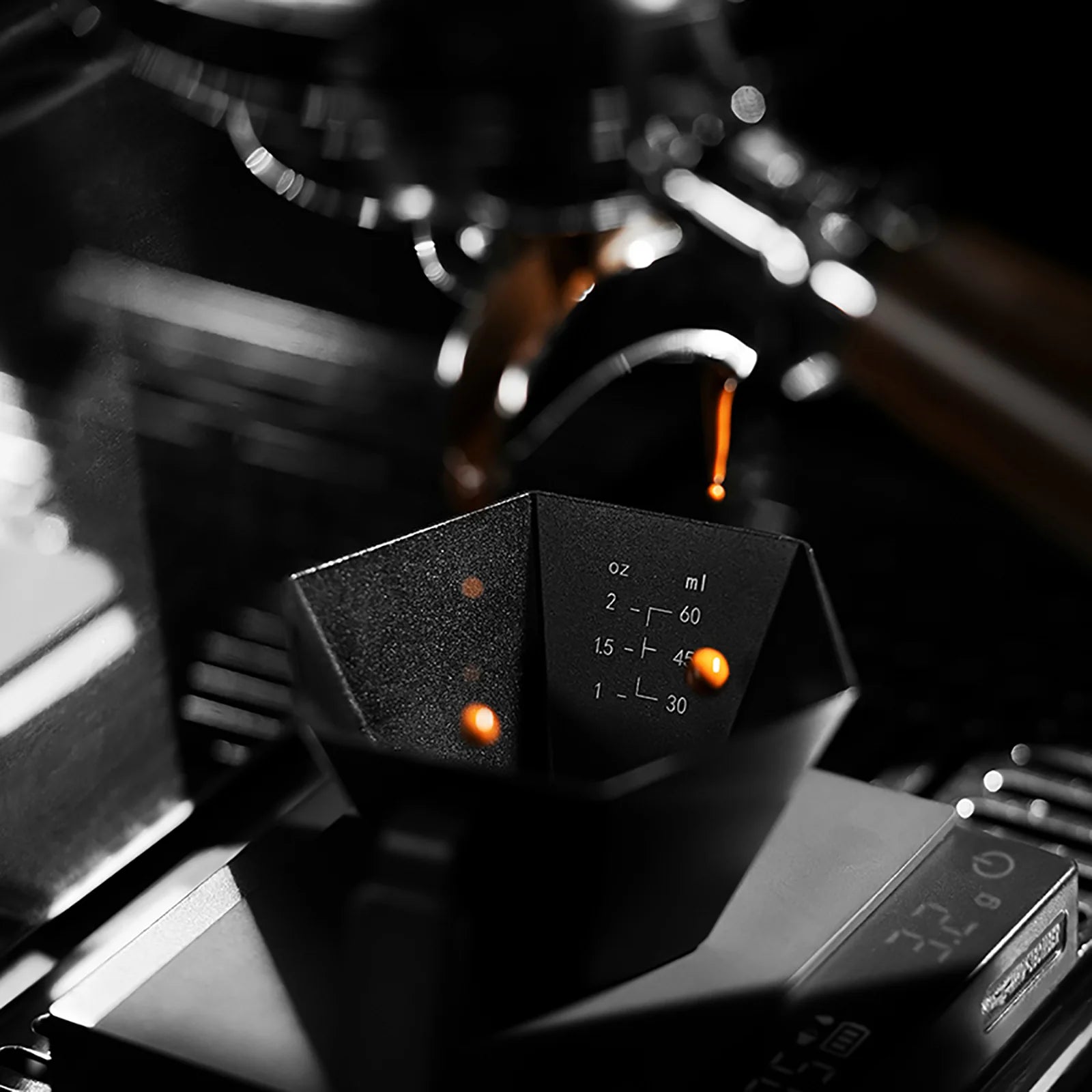 MHW-3BOMBER Prism Measuring Cup in black. Hexagonal shape, dual scale markings in ml/oz. Espresso drops inside.