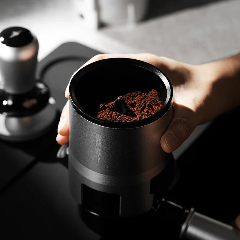 MHW-3BOMBER SE Pro espresso shaker funnel in use, filled with ground coffee. Gray color.