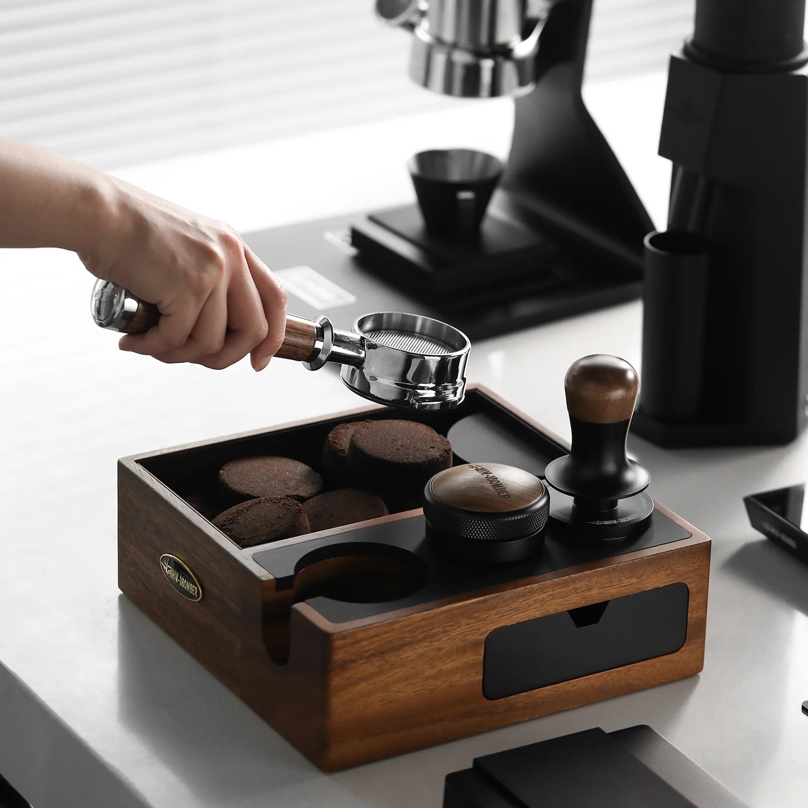 MHW-3BOMBER knock box station with portafilter and tamper, walnut wood finish. Espresso making on counter.
