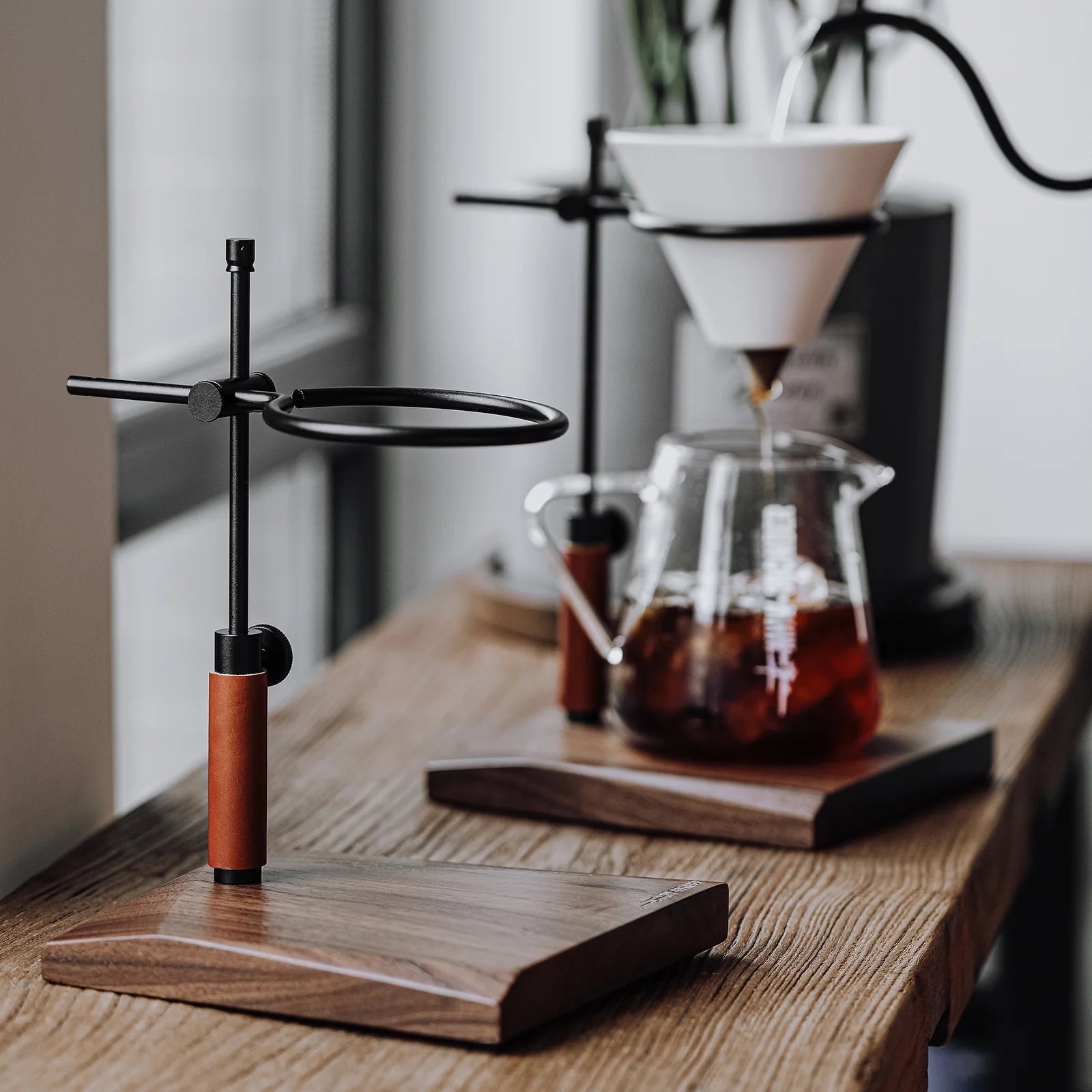 MHW-3BOMBER adjustable coffee dripper stand with wood base, black aluminum frame, and leather accent. 