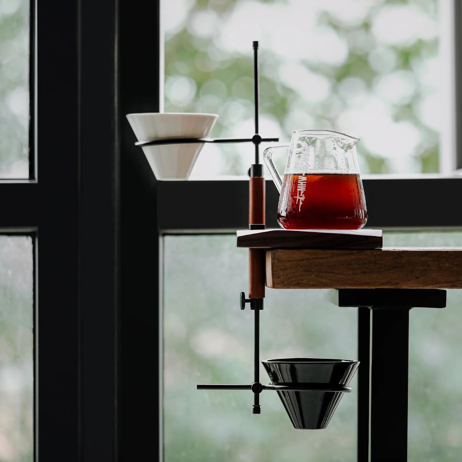 MHW-3BOMBER adjustable coffee dripper stand with glass pot, brown handle, and white/black funnels. 